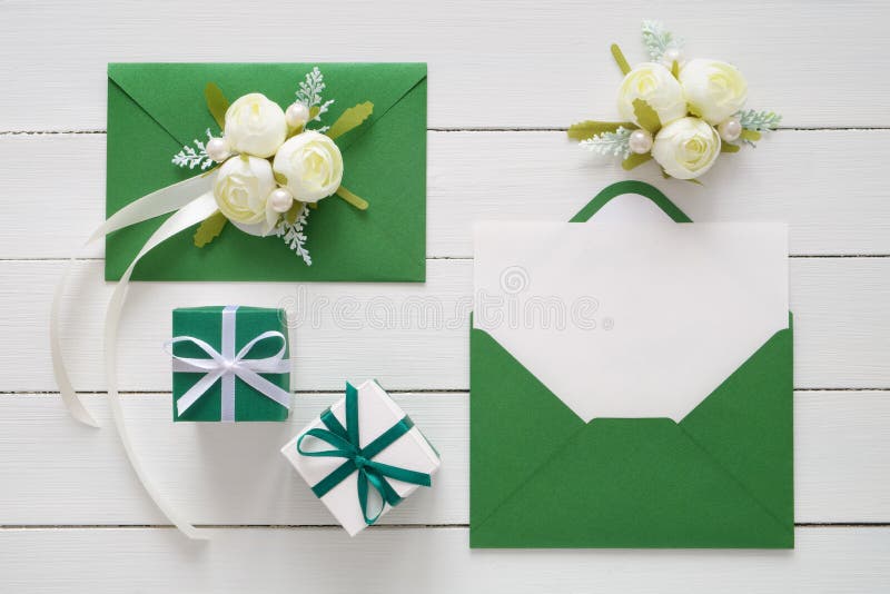 工作区 婚礼邀请卡片、缎丝带、白玫瑰和绿色